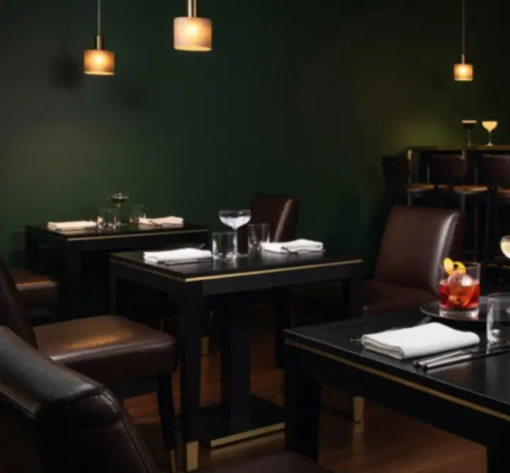 Sfeervol bar-interieur van Knit Vibe NL met warme amberverlichting en diepe groentinten.